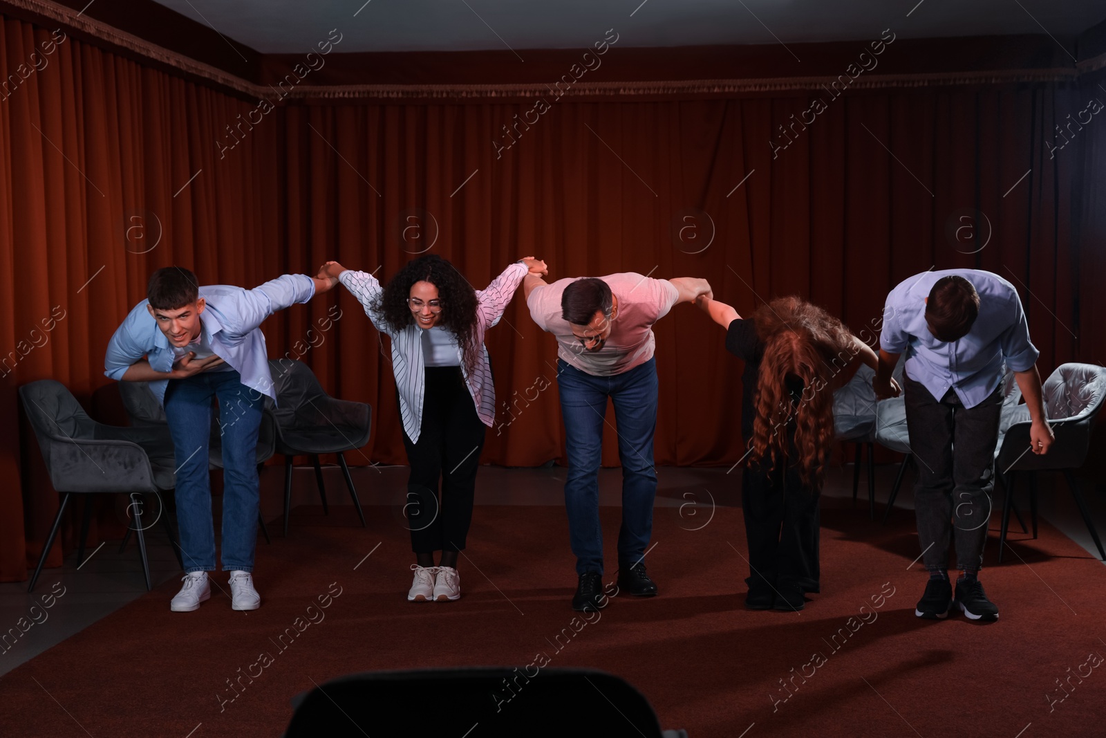 Photo of Professional actors bowing on stage in theatre