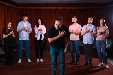 Photo of Professional actors bowing on stage in theatre