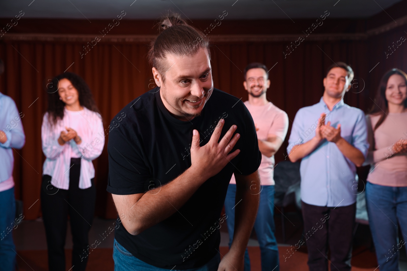 Photo of Professional actors bowing on stage in theatre