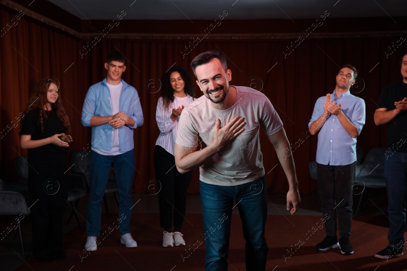 Photo of Professional actors bowing on stage in theatre