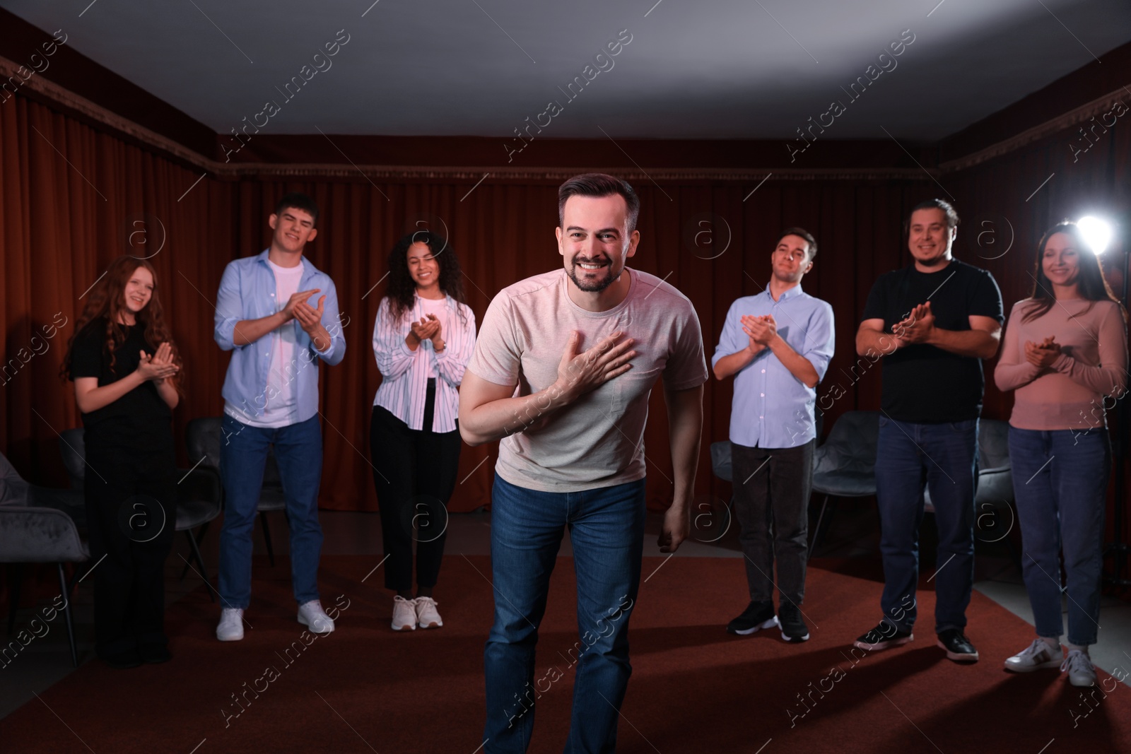 Photo of Professional actors bowing on stage in theatre