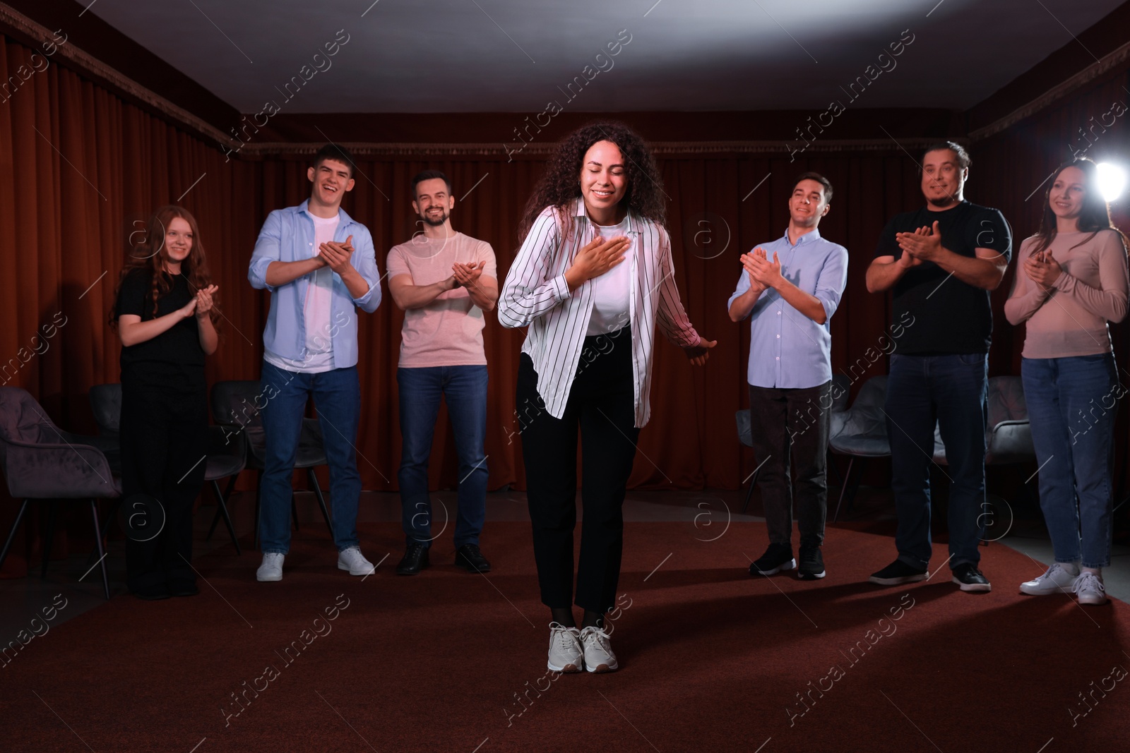 Photo of Professional actors bowing on stage in theatre