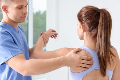 Photo of Osteopath working with patient in clinic. Manual therapy