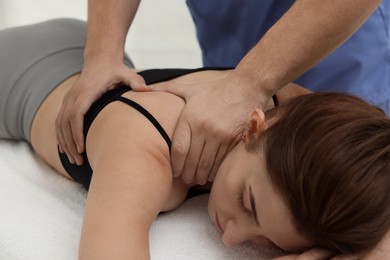 Osteopath massaging woman's back on couch indoors, closeup. Manual therapy