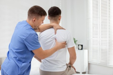 Photo of Osteopath working with patient in clinic. Manual therapy