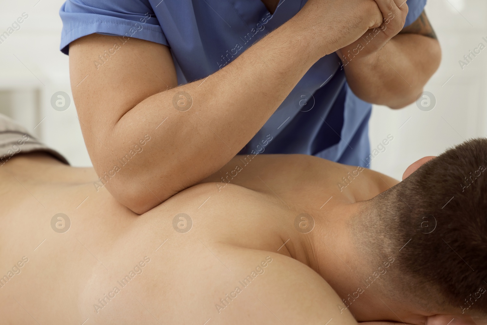 Photo of Osteopath massaging man's back in clinic, closeup. Manual therapy