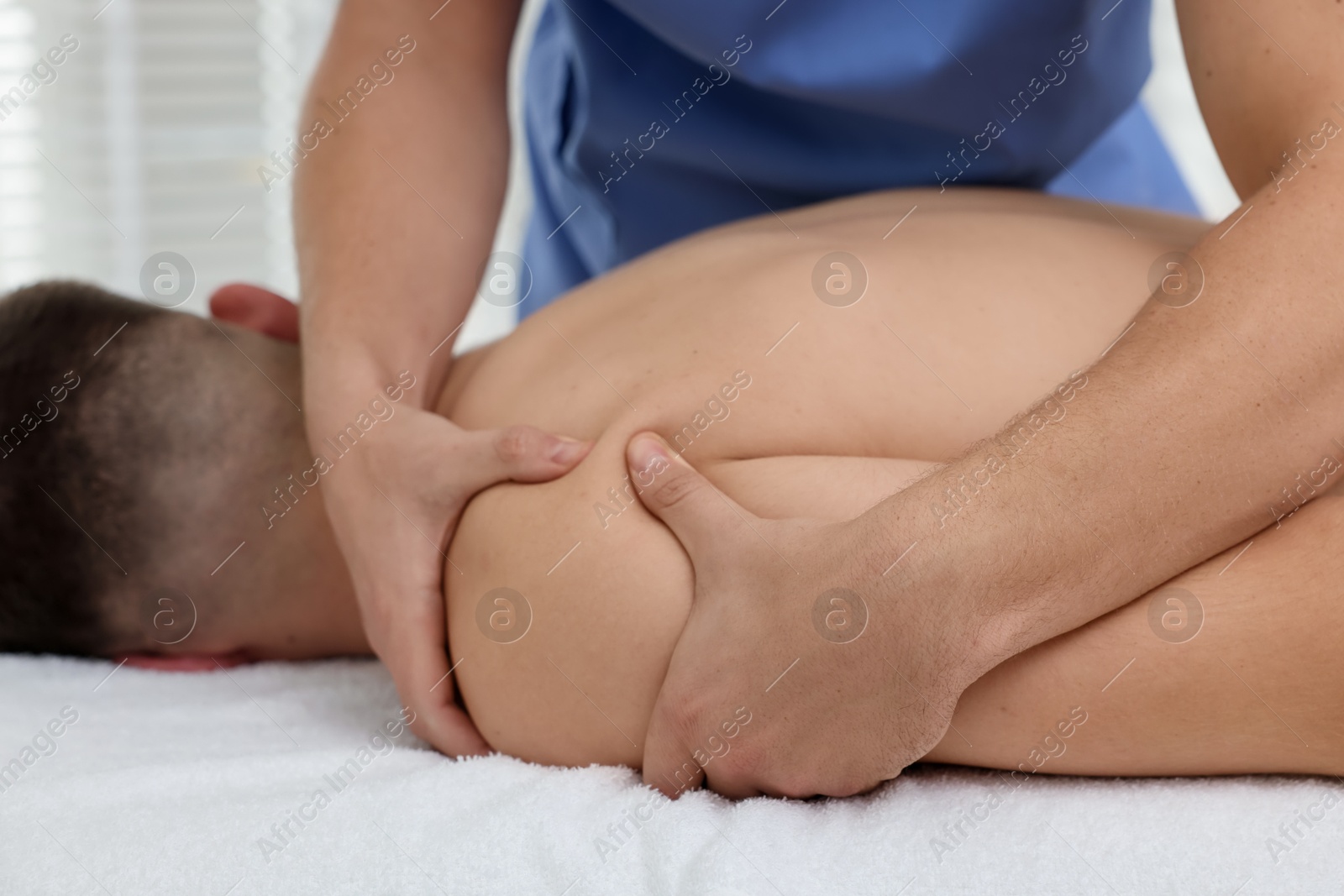 Photo of Osteopath massaging man's arm in clinic, closeup. Manual therapy