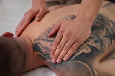 Photo of Massage therapist working with patient in clinic, closeup