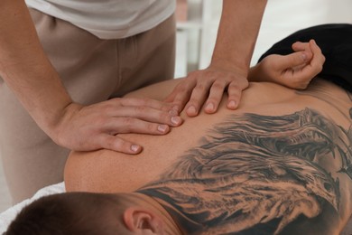 Photo of Massage therapist working with patient in clinic, closeup