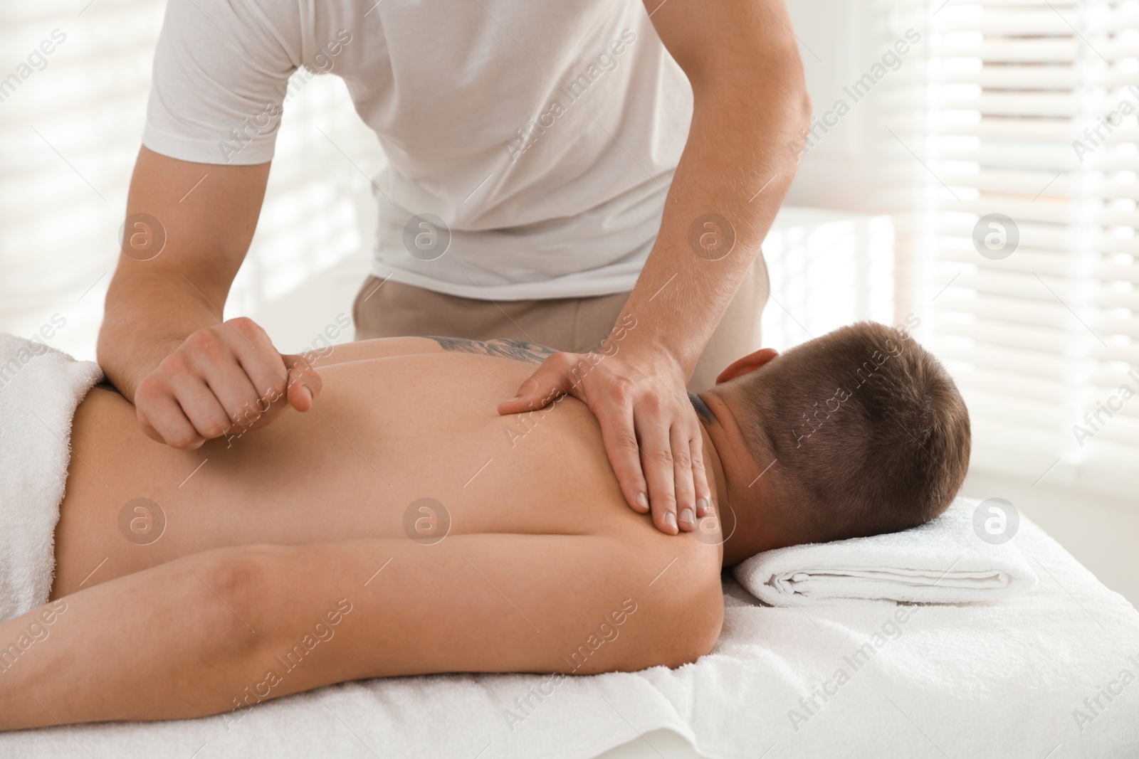 Photo of Massage therapist working with patient in clinic, closeup