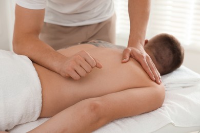 Photo of Massage therapist working with patient in clinic, closeup