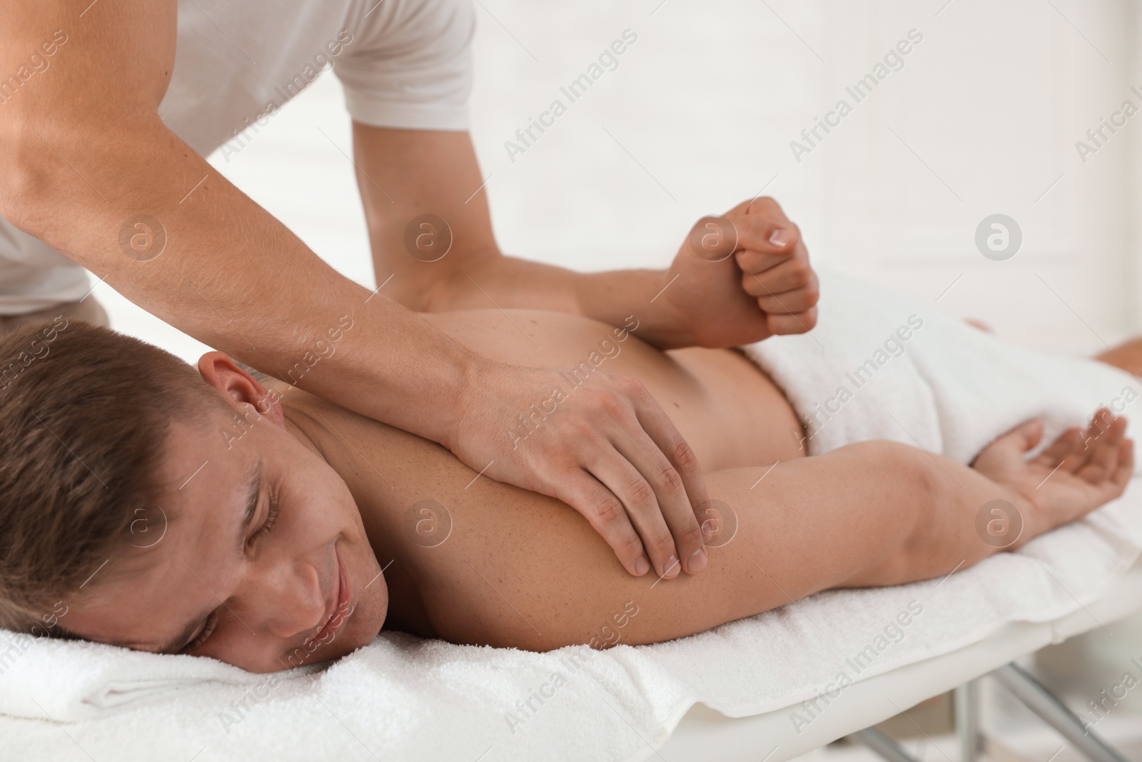 Photo of Massage therapist working with patient in clinic, closeup