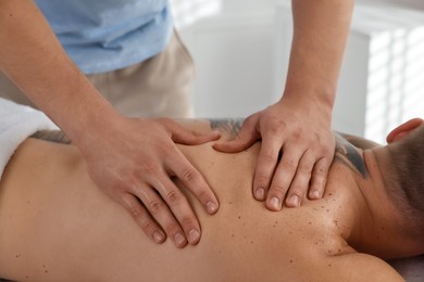 Photo of Massage therapist working with patient in clinic, closeup