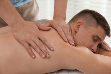 Photo of Massage therapist working with patient in clinic, closeup