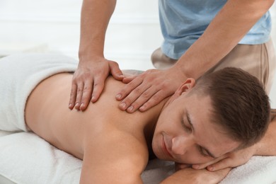 Photo of Massage therapist working with patient in clinic, closeup