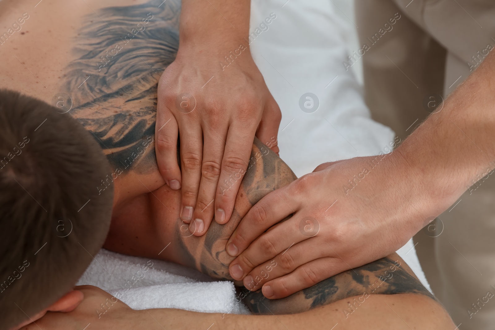 Photo of Massage therapist working with patient in clinic, closeup