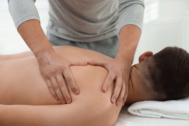 Photo of Massage therapist working with patient in clinic, closeup