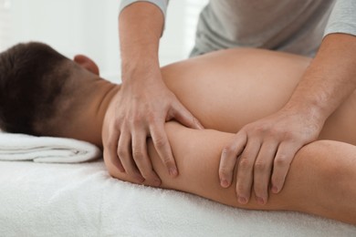 Photo of Massage therapist working with patient in clinic, closeup