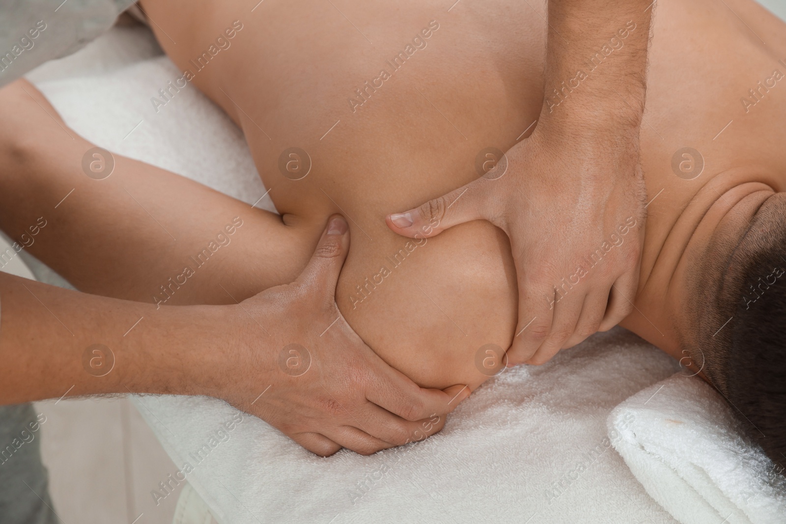 Photo of Massage therapist working with patient in clinic, closeup