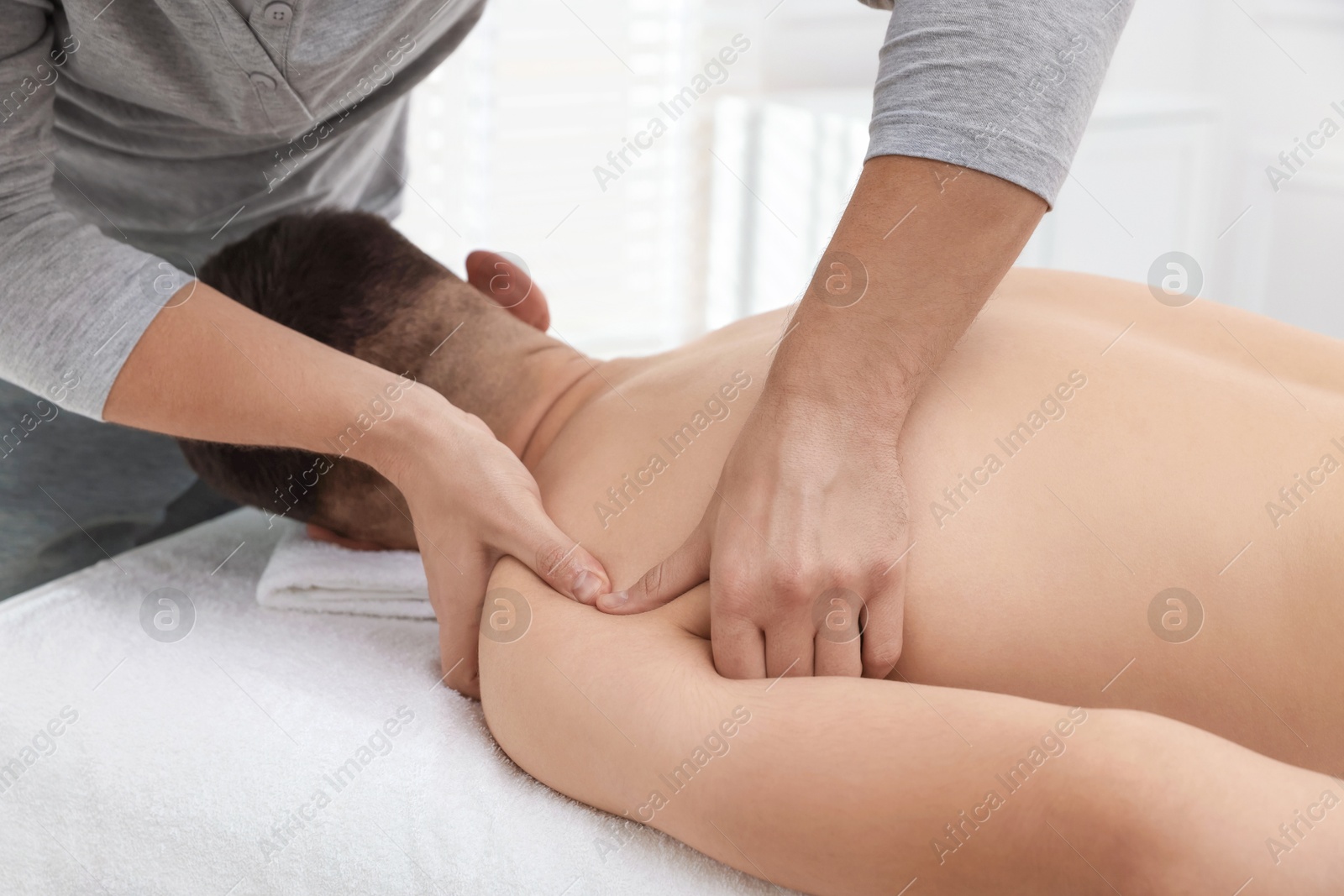 Photo of Massage therapist working with patient in clinic, closeup