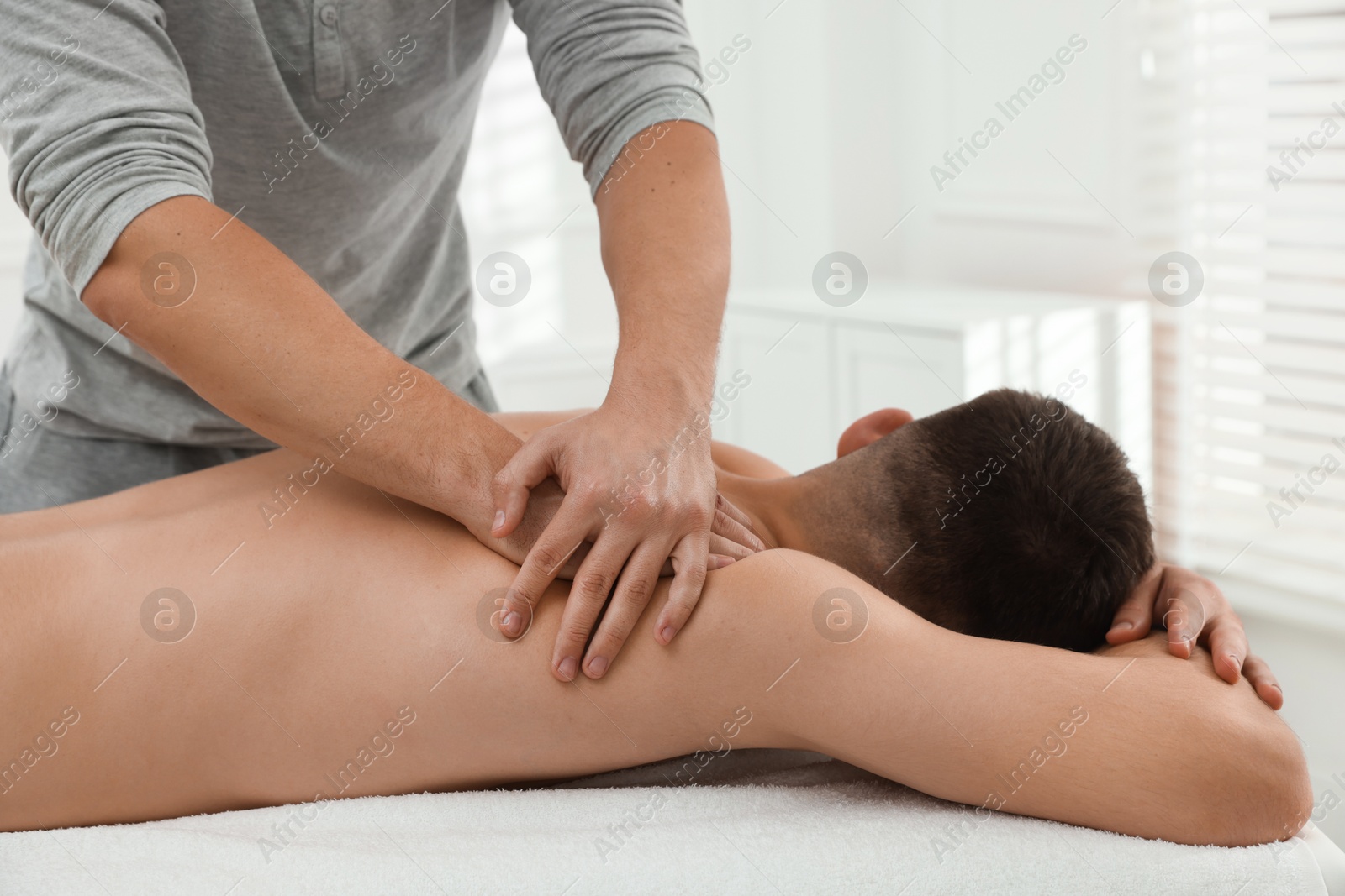 Photo of Massage therapist working with patient in clinic, closeup