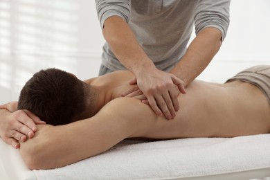 Photo of Massage therapist working with patient in clinic, closeup