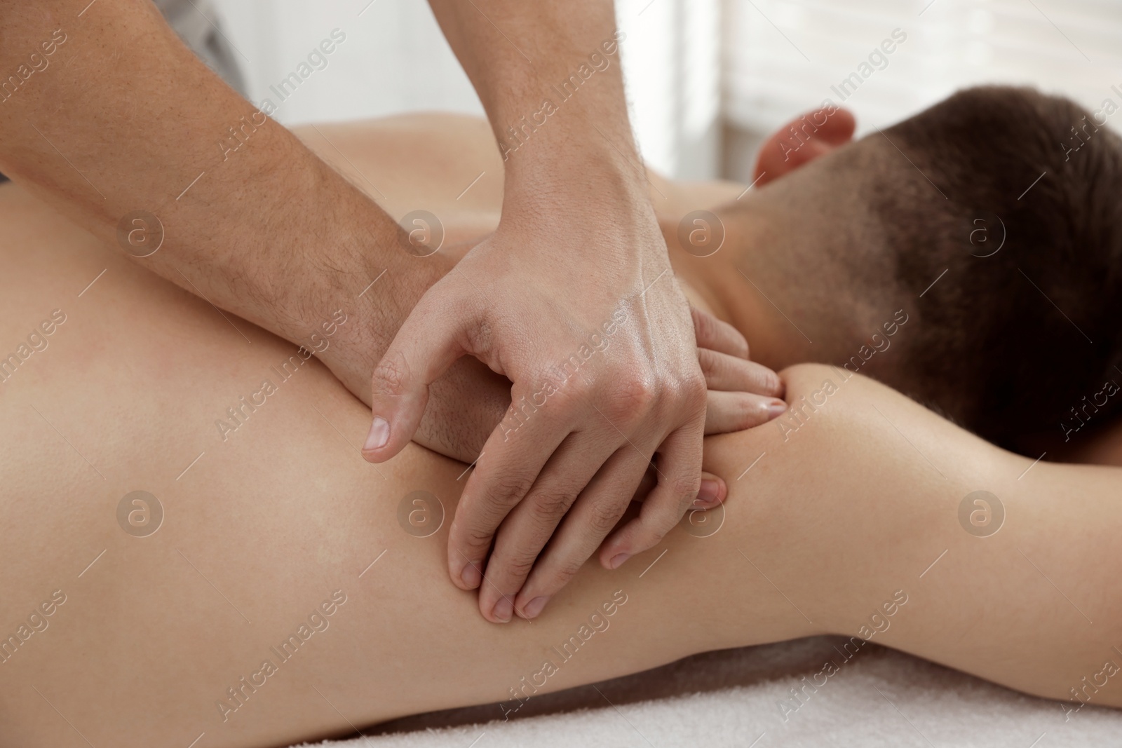 Photo of Massage therapist working with patient in clinic, closeup