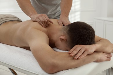 Photo of Massage therapist working with patient in clinic, closeup