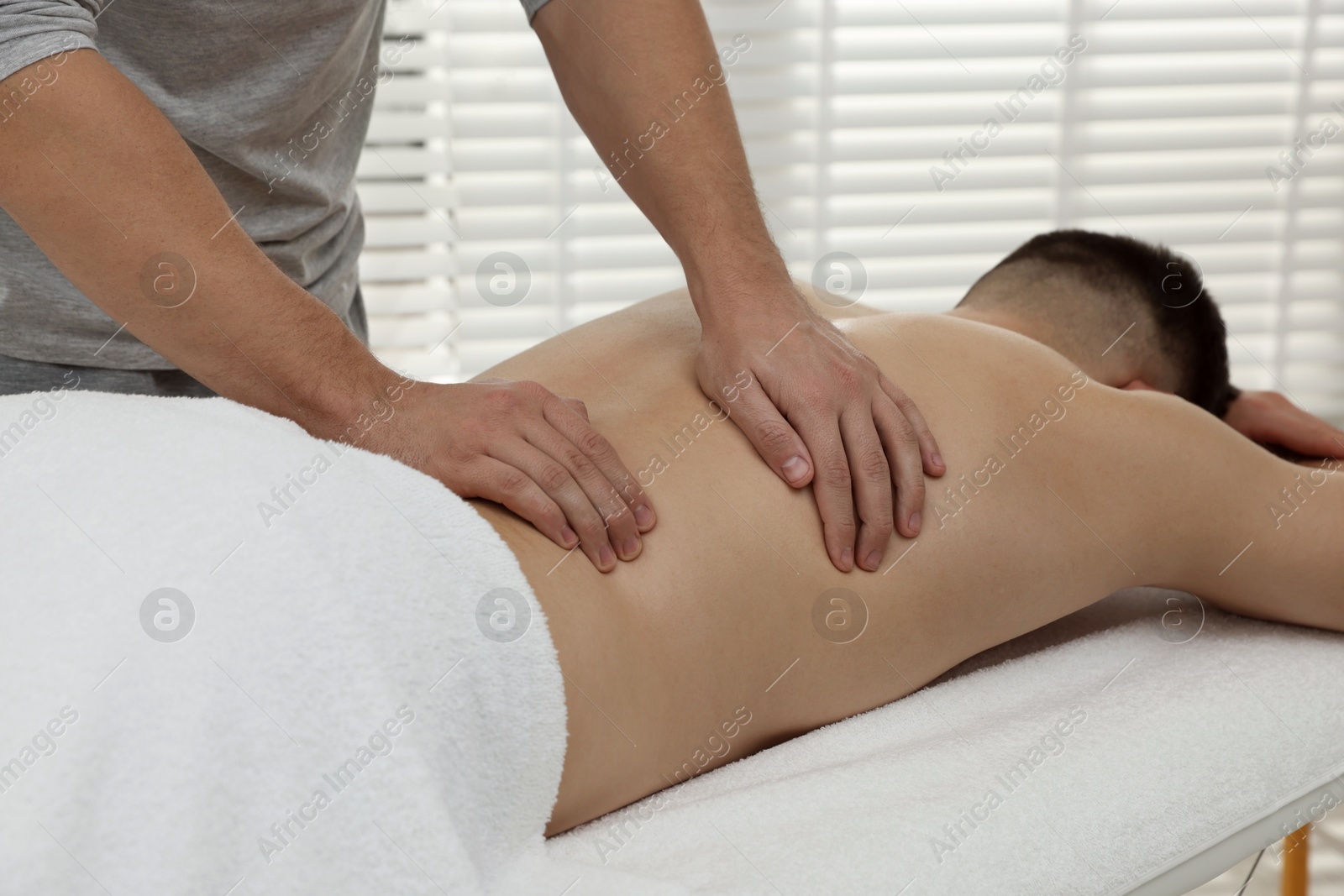 Photo of Massage therapist working with patient in clinic, closeup