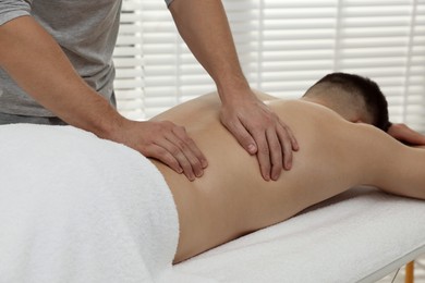 Photo of Massage therapist working with patient in clinic, closeup