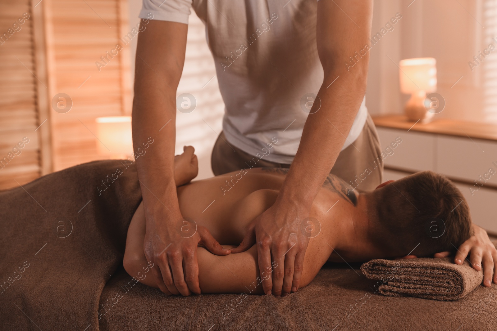 Photo of Massage therapist working with patient in clinic, closeup