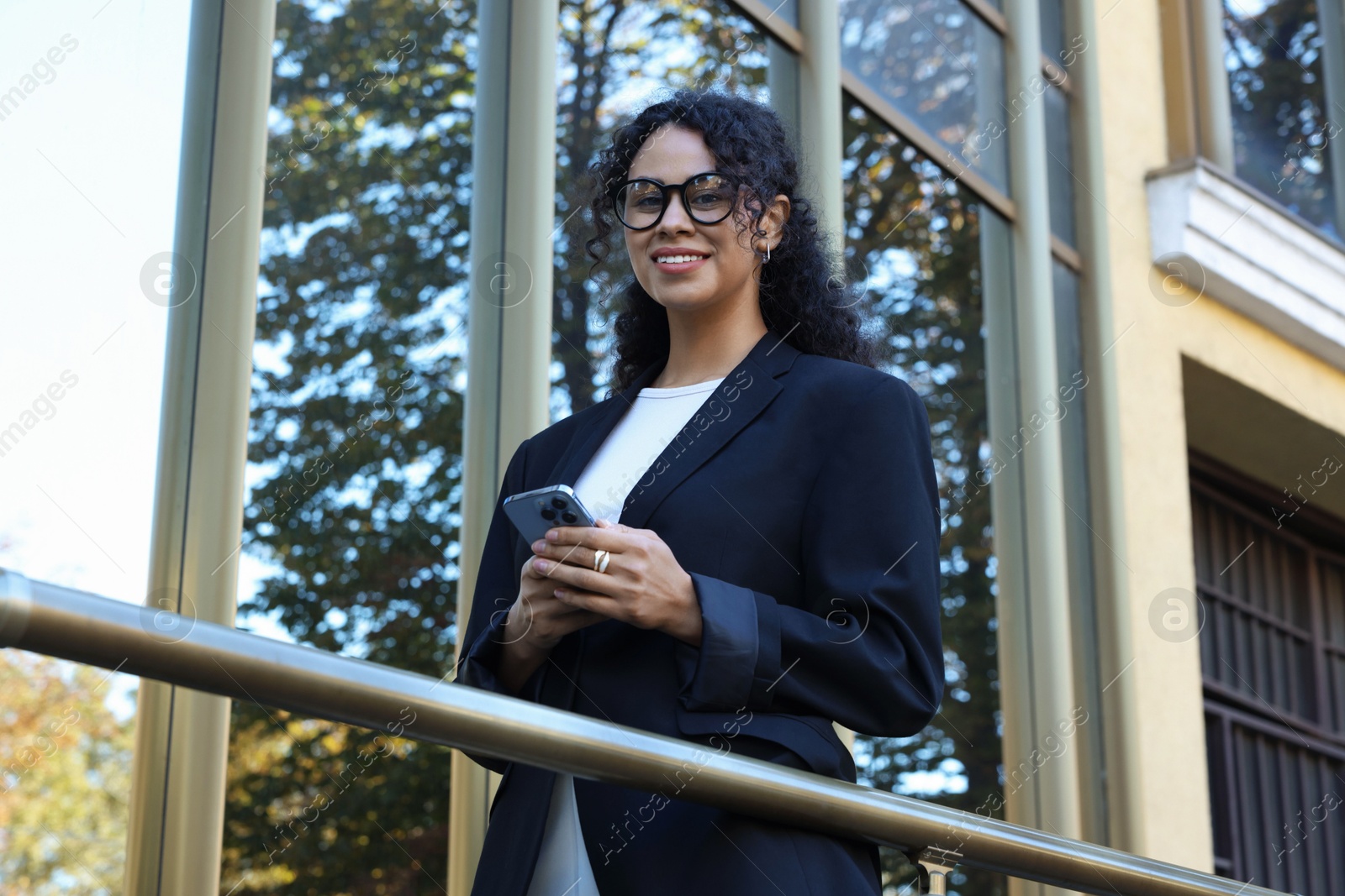 Photo of Portrait of young woman with phone wearing stylish suit outdoors