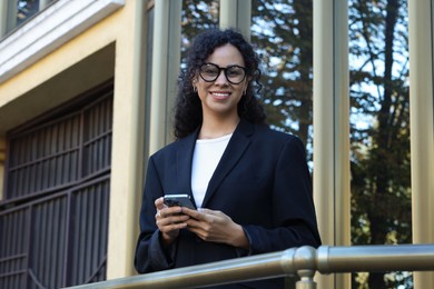 Photo of Portrait of young woman with phone wearing stylish suit outdoors