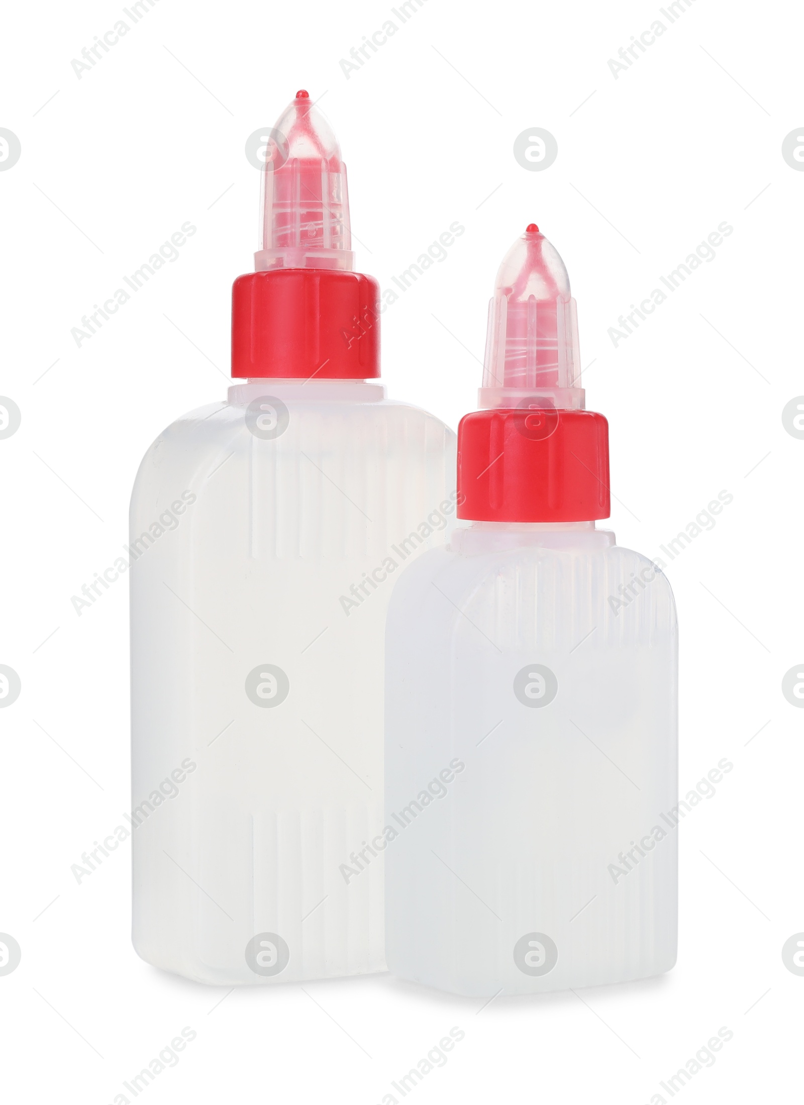 Photo of Bottles of glue with caps isolated on white