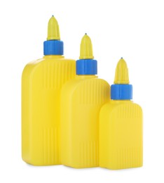 Photo of Bottles of glue with caps isolated on white