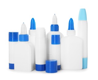 Photo of Bottles and sticks of glue on white background