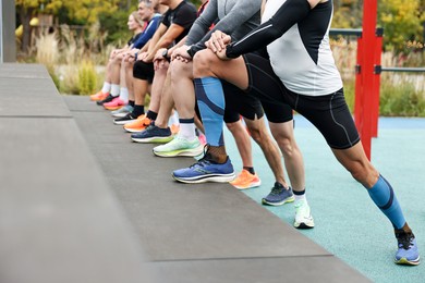 Photo of Group of people stretching in park, closeup