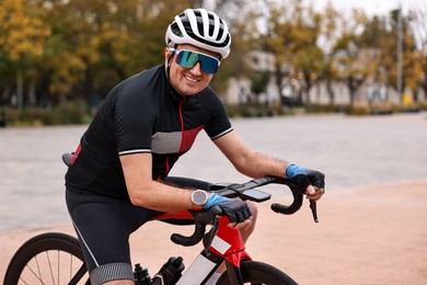 Photo of Athletic man with helmet and bicycle outdoors