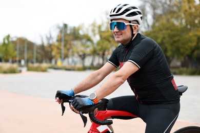 Photo of Athletic man with helmet and bicycle outdoors