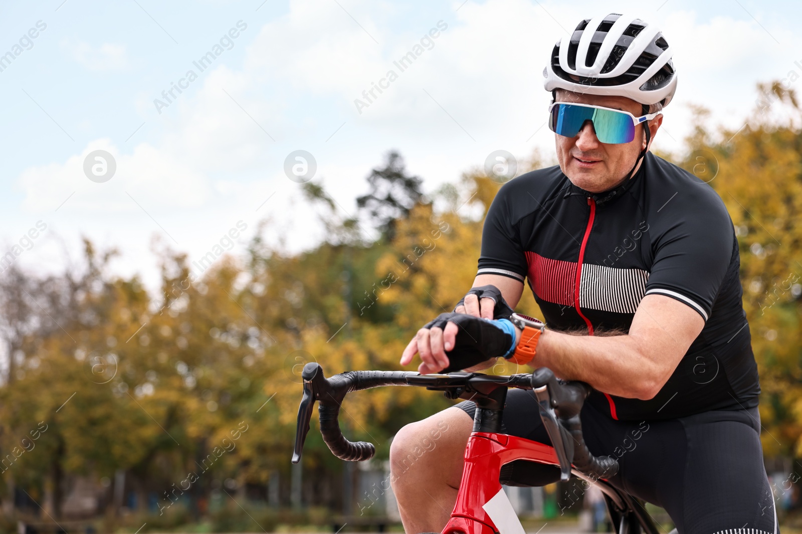 Photo of Athletic man with helmet and bicycle outdoors, space for text