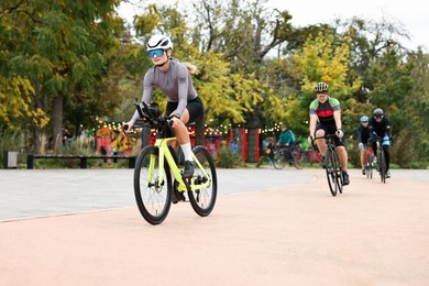 Photo of Group of athletic people riding bicycles outdoors