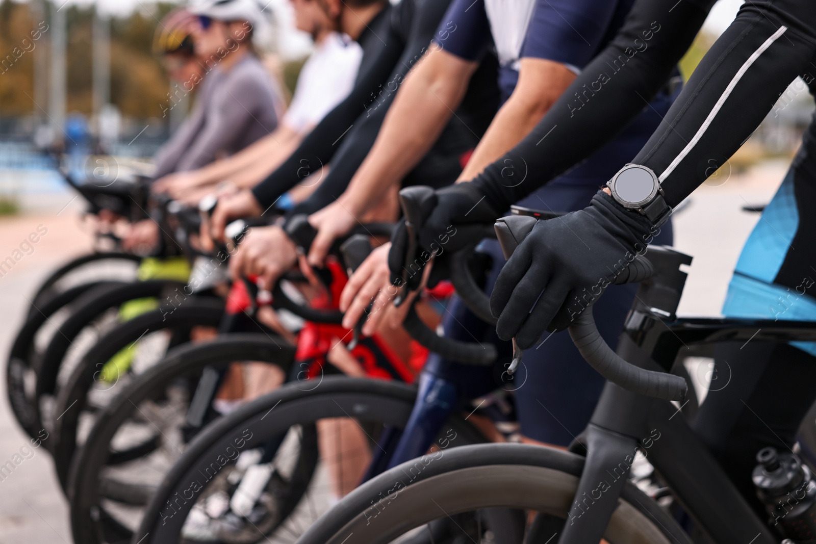 Photo of Group of athletic people with bicycles outdoors, closeup