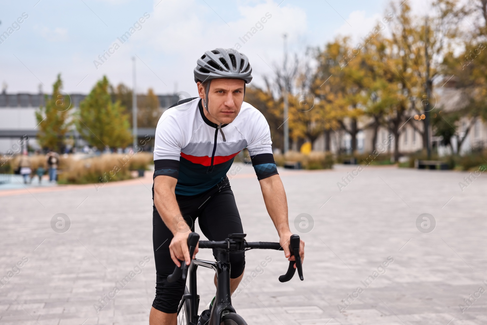 Photo of Athletic man with helmet riding bicycle outdoors