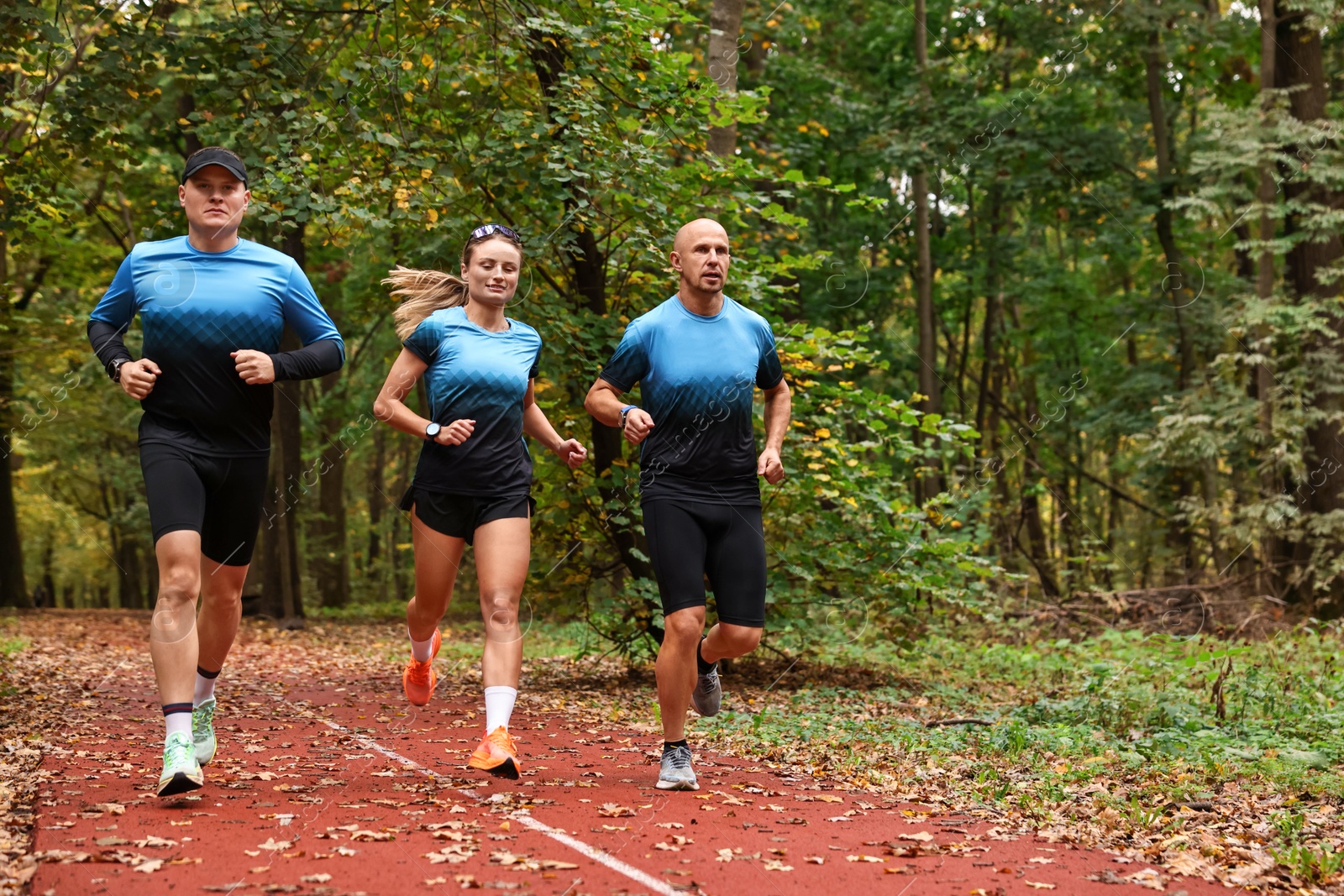 Photo of Group of athletic people running in park. Space for text