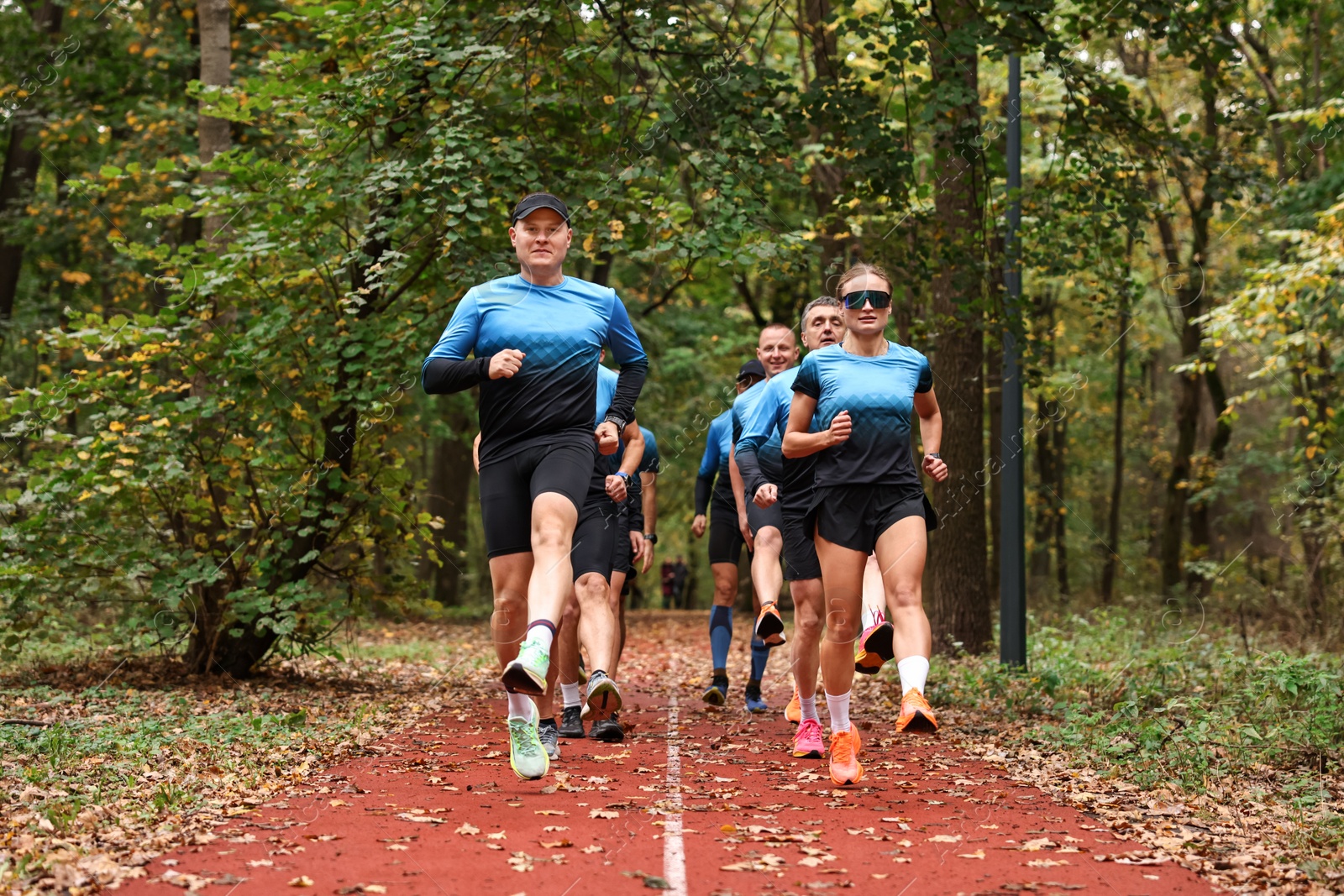 Photo of Group of athletic people running in park