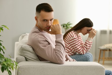 Photo of Offended couple ignoring each other at home