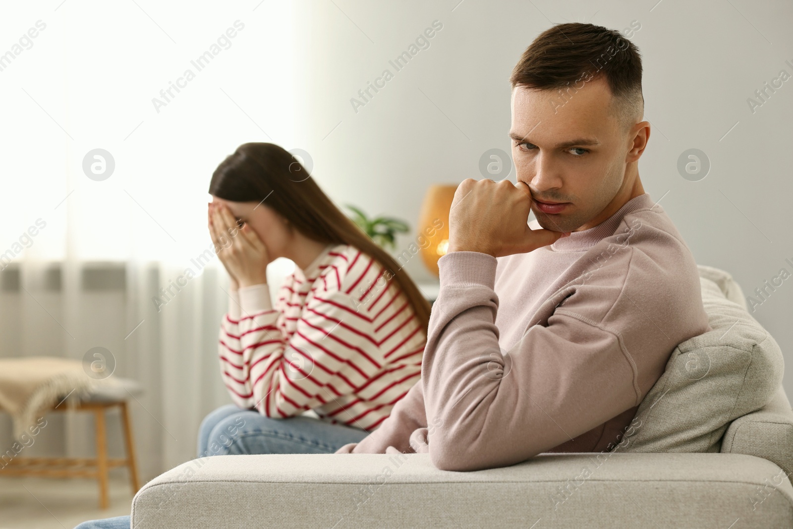 Photo of Offended couple ignoring each other at home