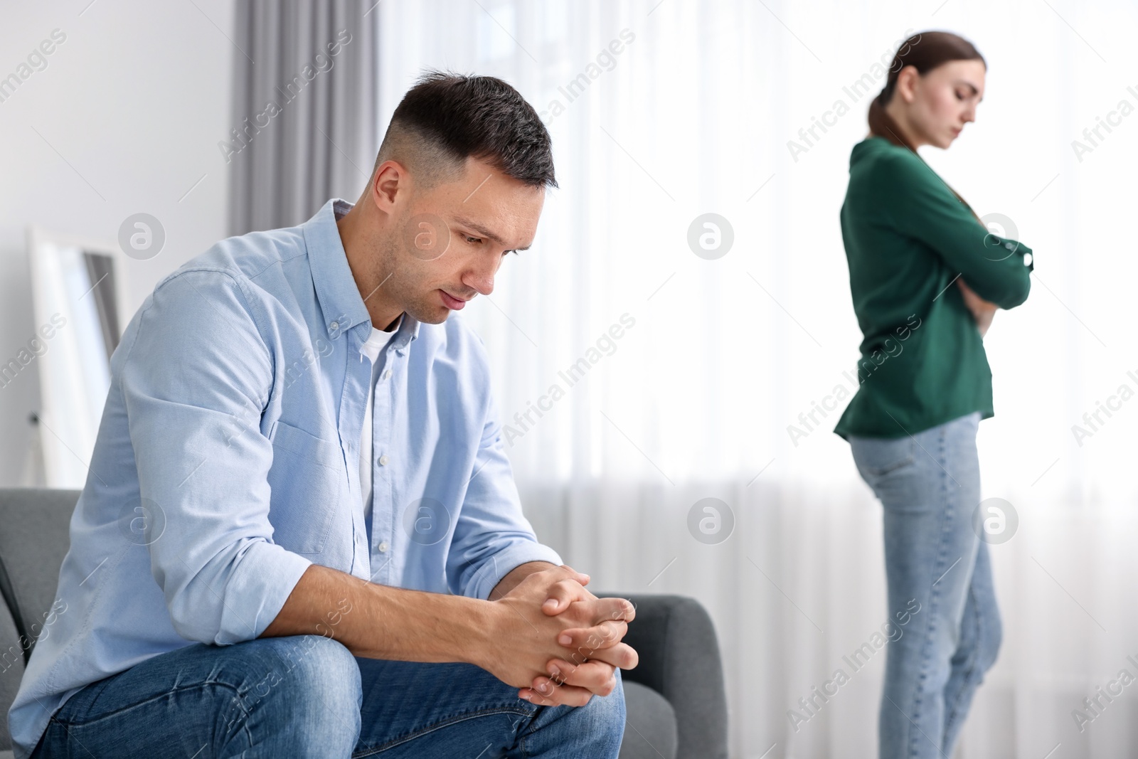 Photo of Offended couple ignoring each other at home, selective focus