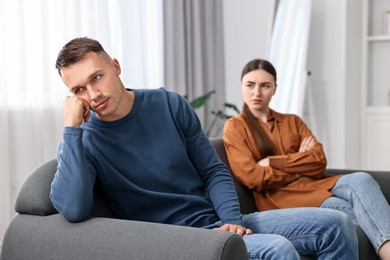 Photo of Upset couple after quarrel at home, selective focus