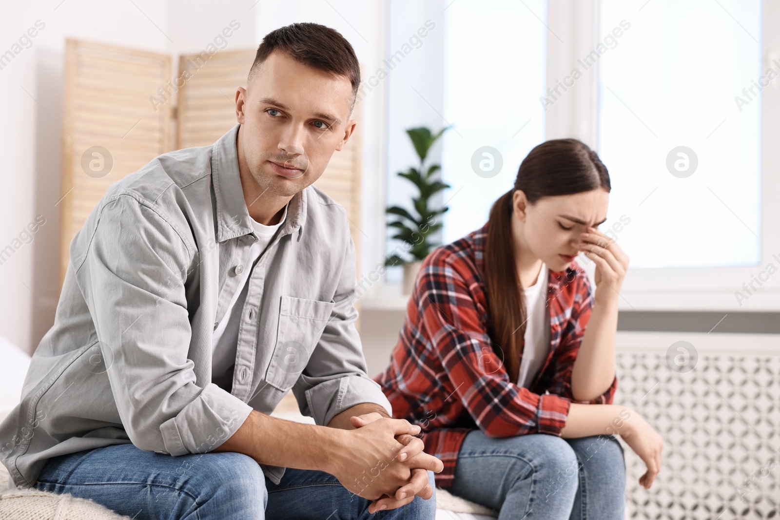 Photo of Offended couple ignoring each other at home